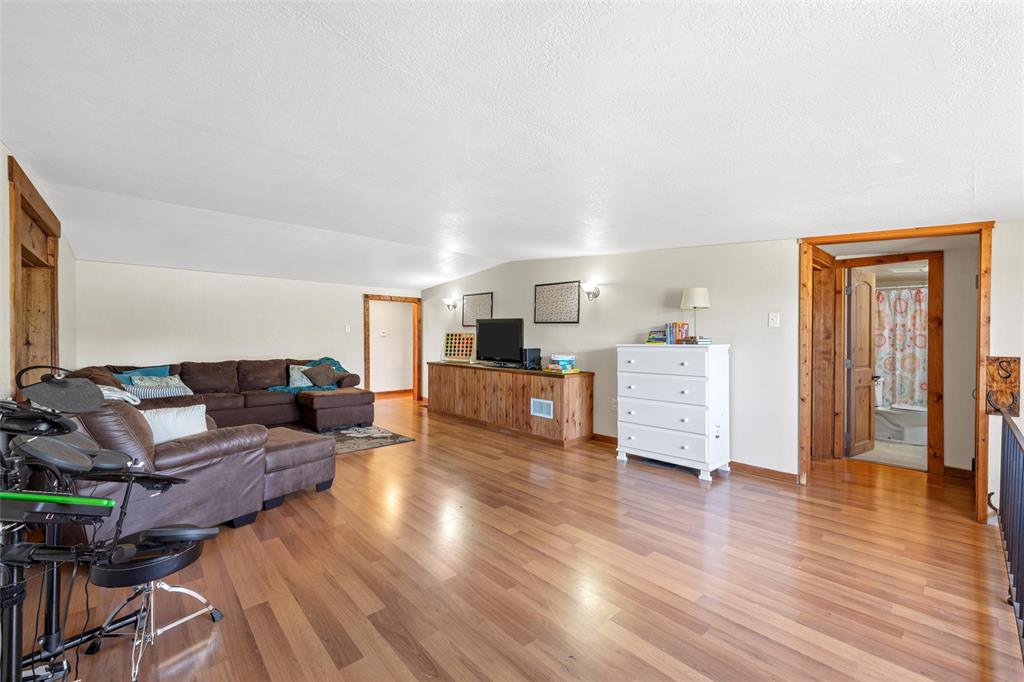 311 Cedar Ridge Drive China Spring, TX 76633 - Photo 10 of 28 Living room with light vinyl wood-style floors, lofted ceiling, and a textured ceiling