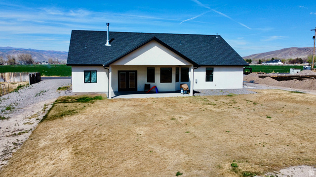 277 West 800 South Monroe, UT 84754 - Photo 40 of 46 Back of property featuring a mountain view, a shingled roof, stucco siding, and a patio