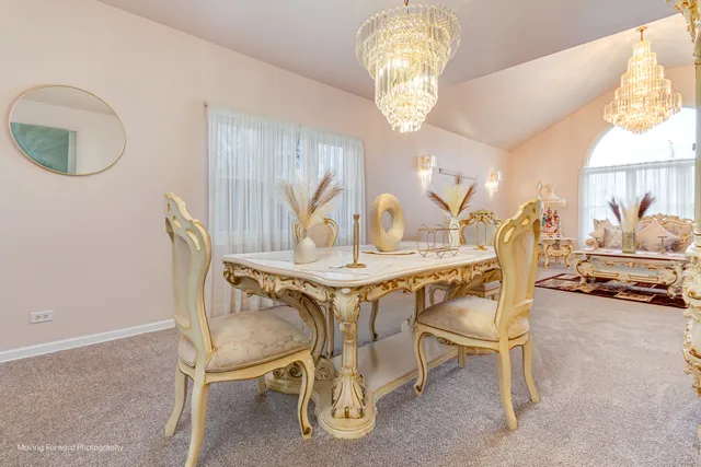 a view of a dining room with furniture and a chandelier