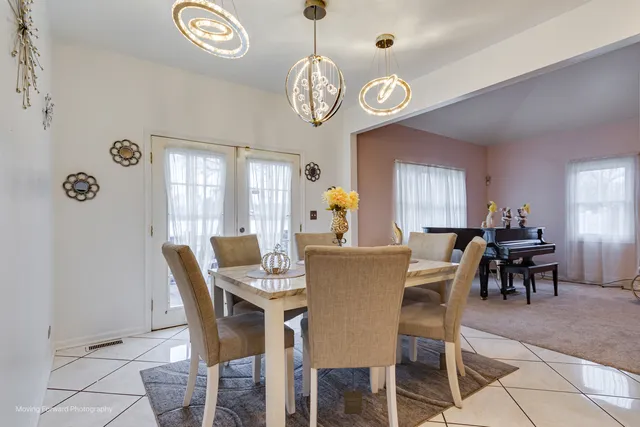 a view of a dining room with furniture a chandelier and a window