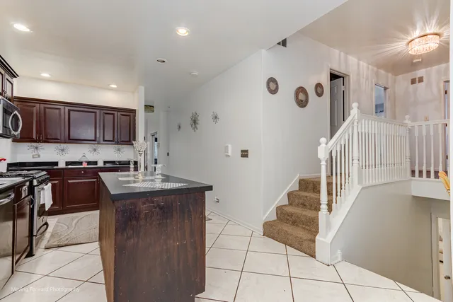 a kitchen with granite countertop a stove a sink and a refrigerator