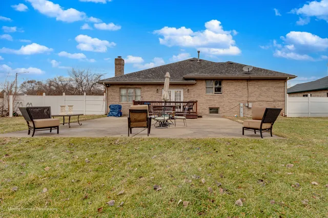 a view of a house with patio chairs and a fire pit