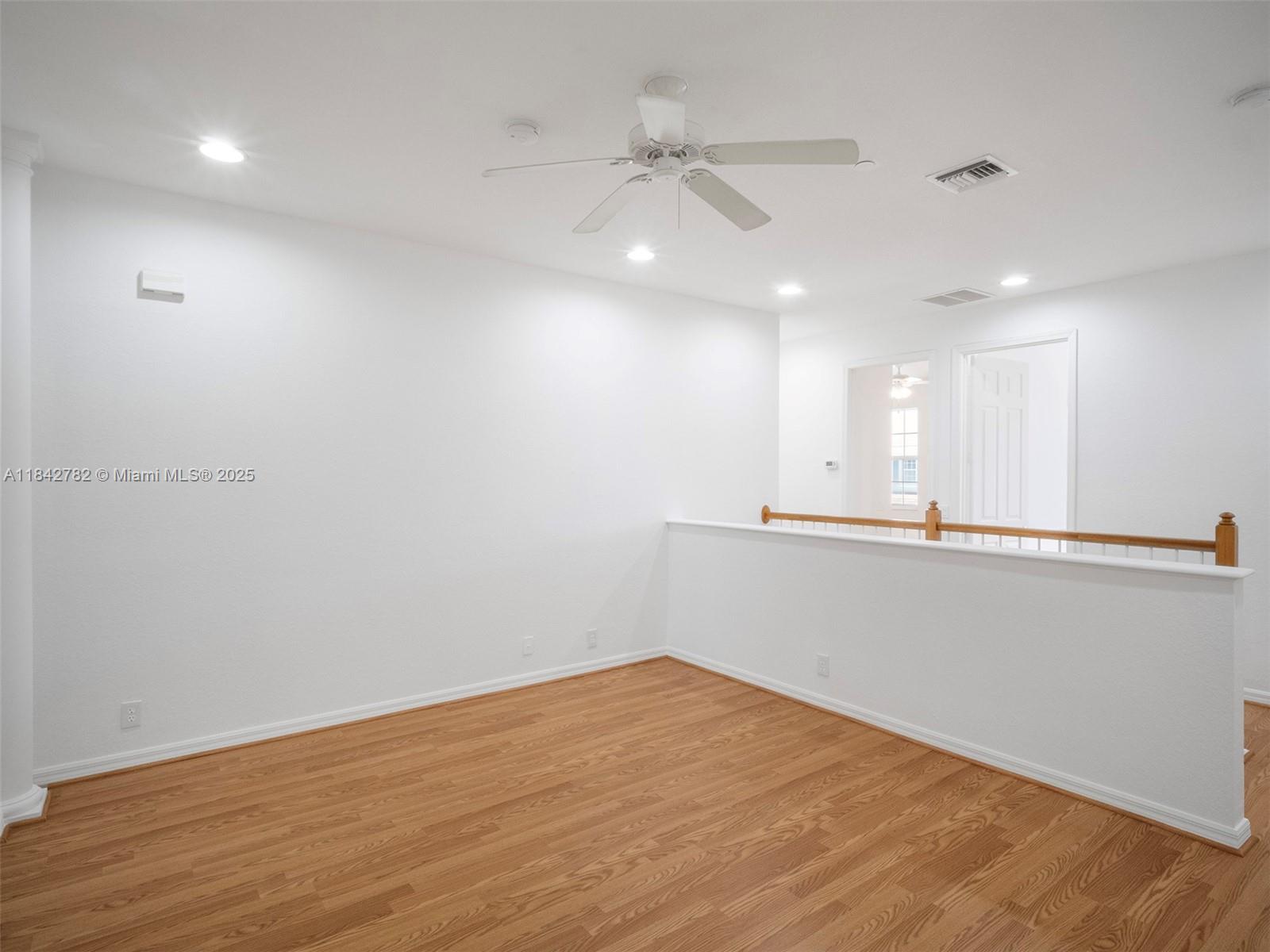 43 Lancaster Road Boynton Beach, FL 33426 - Photo 13 of 29 a view of an empty room with wooden floor and a ceiling fan