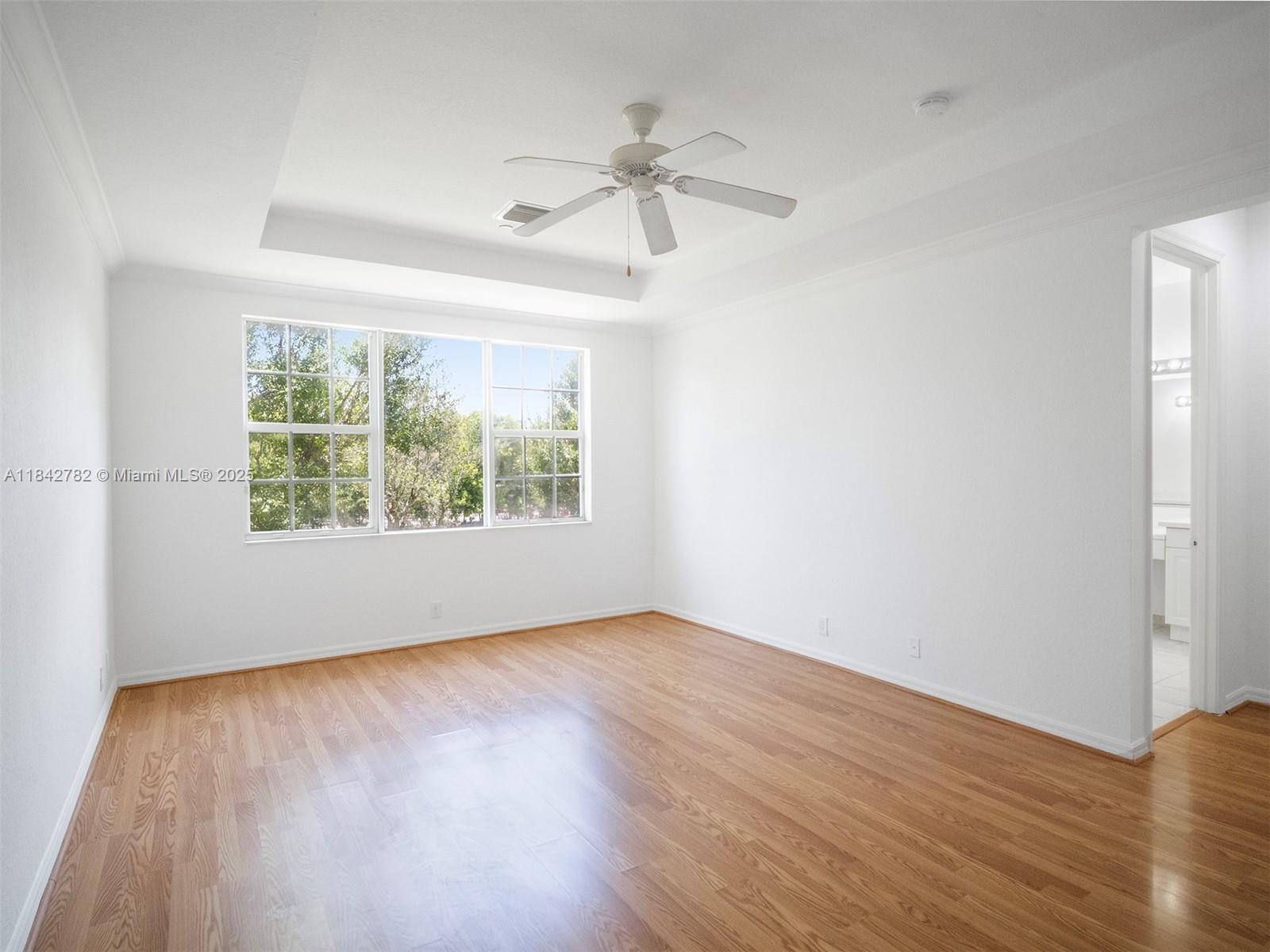 43 Lancaster Road Boynton Beach, FL 33426 - Photo 14 of 29 an empty room with wooden floor chandelier fan and windows