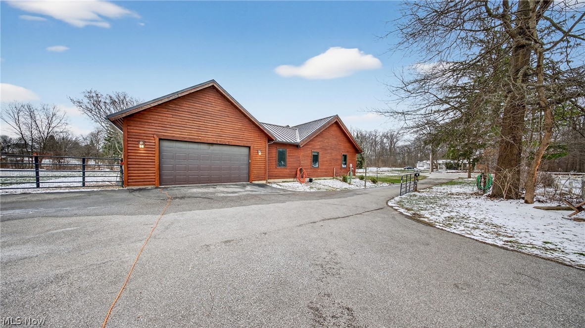 1693 Middleton Road Hudson, OH 44236 - Photo 41 of 48 View of snow covered exterior with a garage, faux log siding, asphalt driveway, and a metal roof