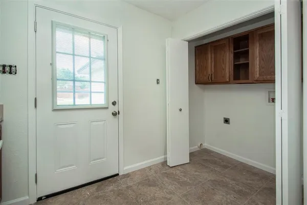 a view of an empty room with window and closet area