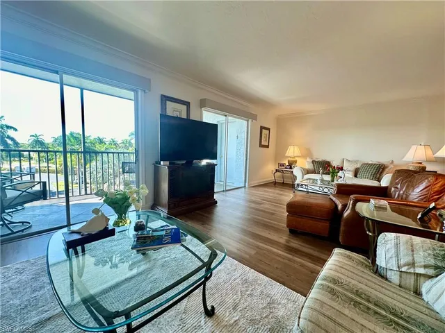 a living room with furniture a flat screen tv and a large window