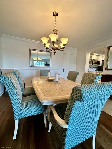 a view of a dining room with furniture and chandelier