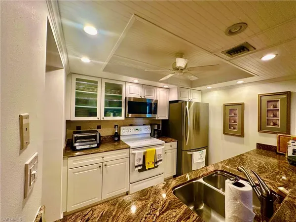 a kitchen that has a lot of cabinets a refrigerator and a stove