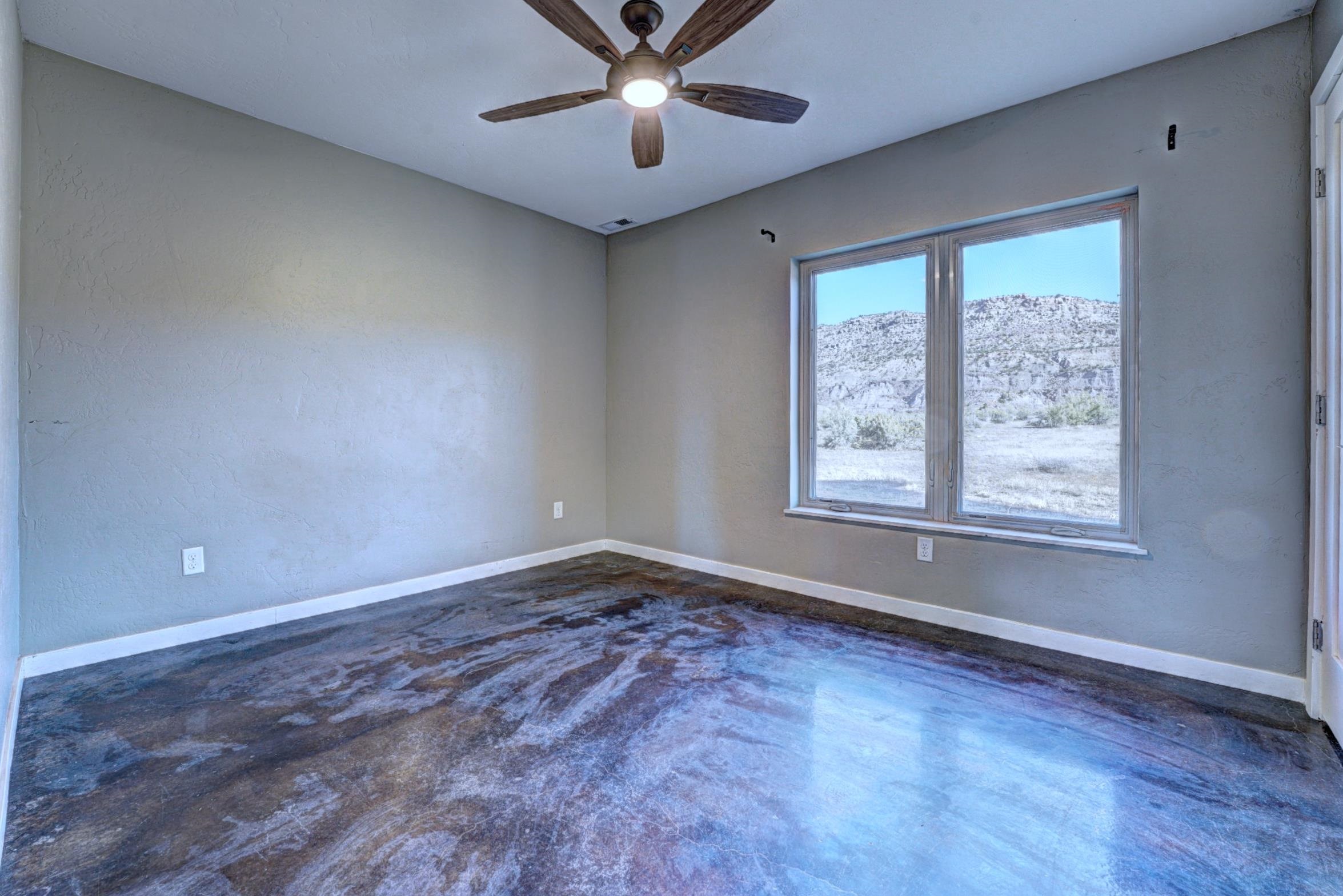 1570-45 45 1/2 Road De Beque, CO 81630 - Photo 19 of 35 a view of an empty room with window and chandelier fan