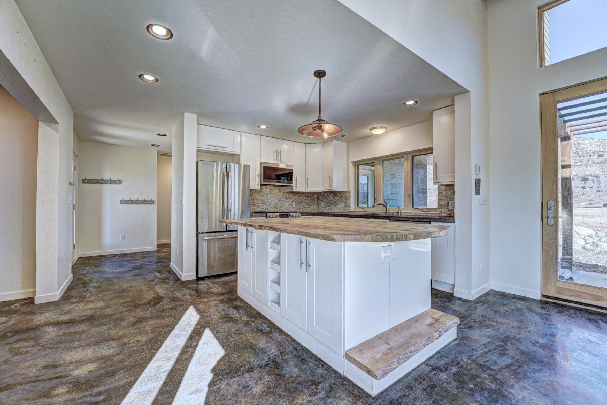 1570-45 45 1/2 Road De Beque, CO 81630 - Photo 5 of 35 a kitchen with kitchen island granite countertop a refrigerator and a sink