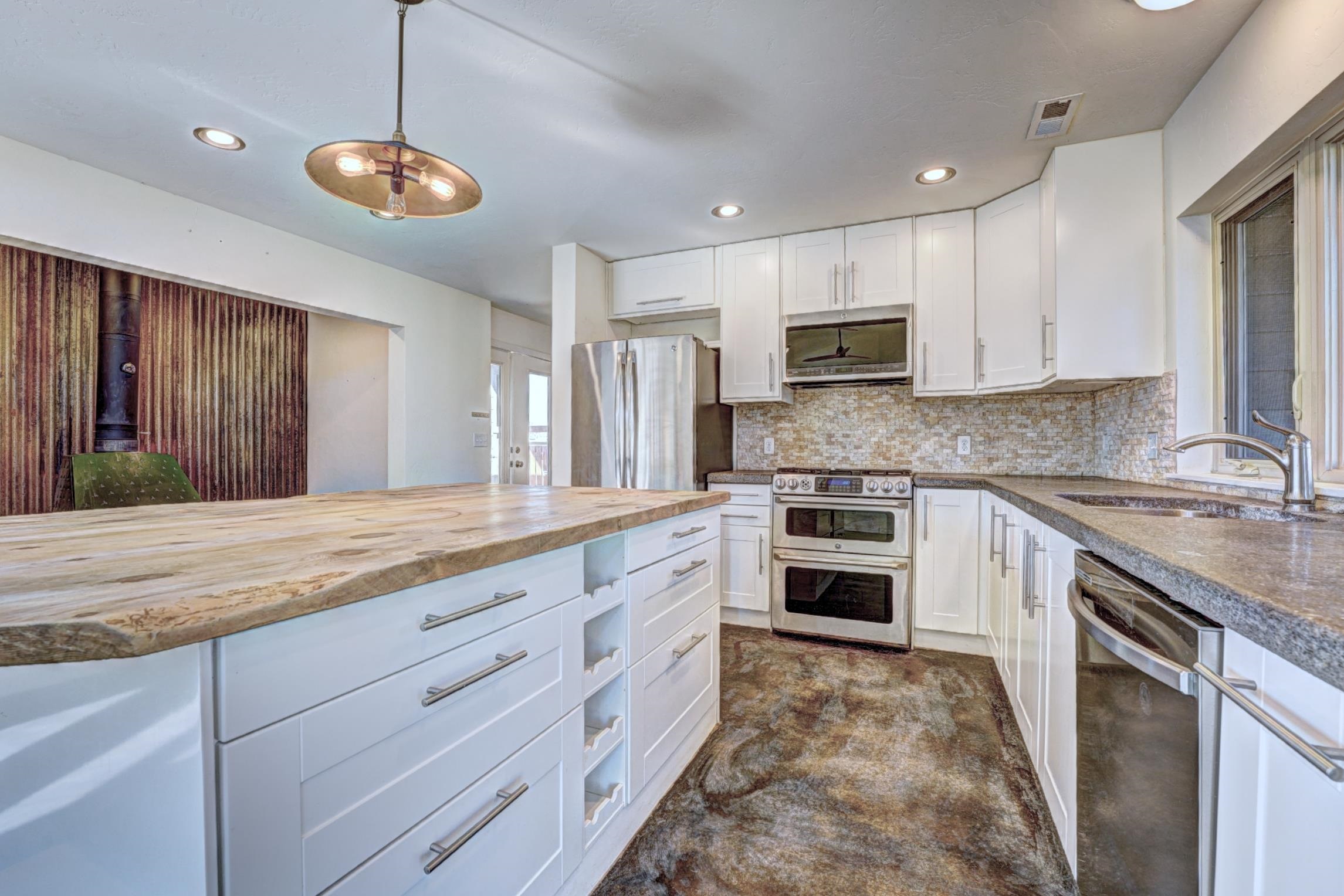 1570-45 45 1/2 Road De Beque, CO 81630 - Photo 6 of 35 a kitchen with stainless steel appliances granite countertop a stove sink and cabinets
