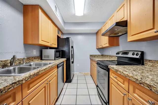 a kitchen with a sink a stove and a microwave