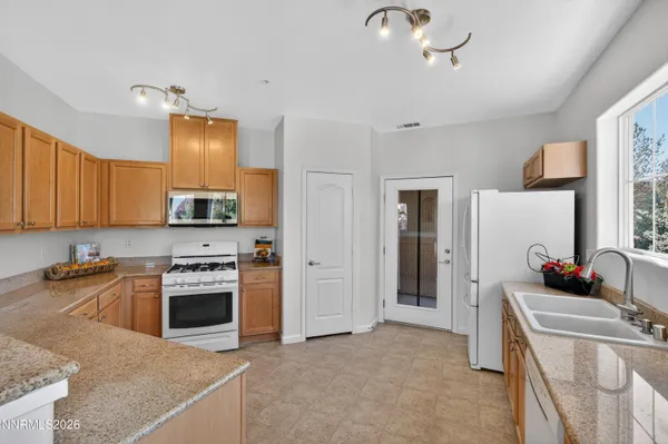 a kitchen with stainless steel appliances granite countertop a sink a stove and a microwave
