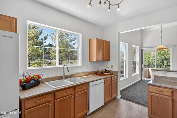 a view of a room with large windows and refrigerator