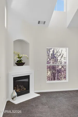 a living room with a fireplace and a potted plant