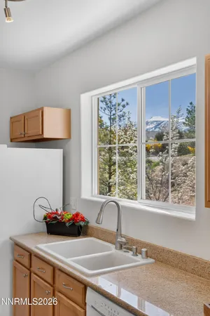 a kitchen with stainless steel appliances granite countertop a stove top oven a sink a refrigerator white cabinets and wooden floor