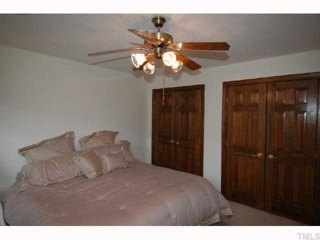 8304 Mourning Dove Road Raleigh, NC 27615 - Photo 6 of 8 a bedroom with a bed and a chandelier