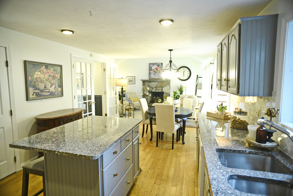 72 Heritage Drive Lowell, MA 01852 - Photo 5 of 29 a dining hall with stainless steel appliances granite countertop a dining table and chairs with wooden floor
