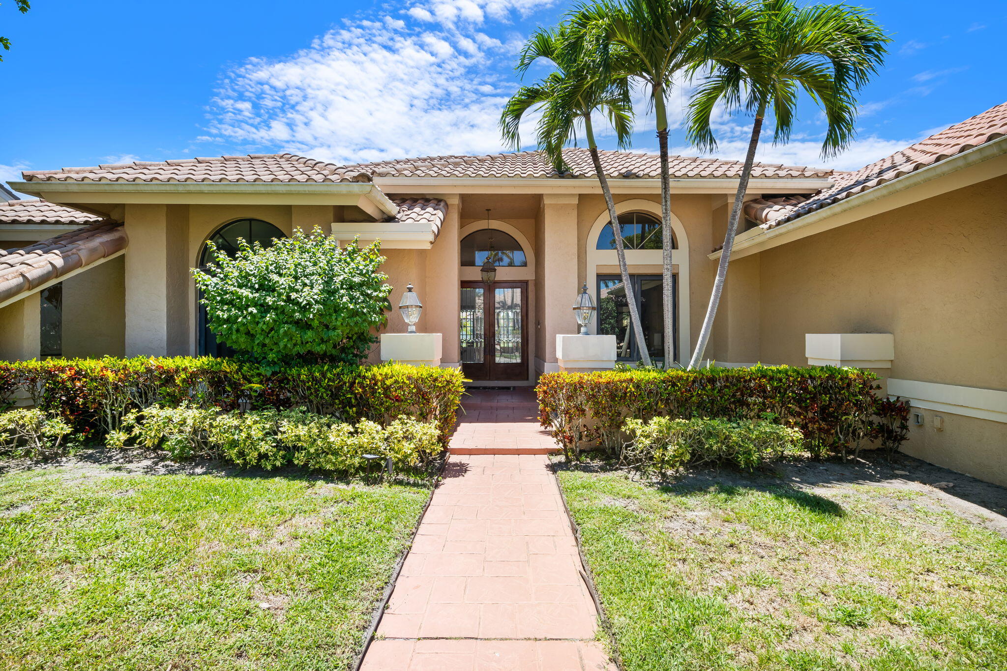 4885 Regency Court Boca Raton, FL 33434 - Photo 2 of 38 a front view of a house with garden