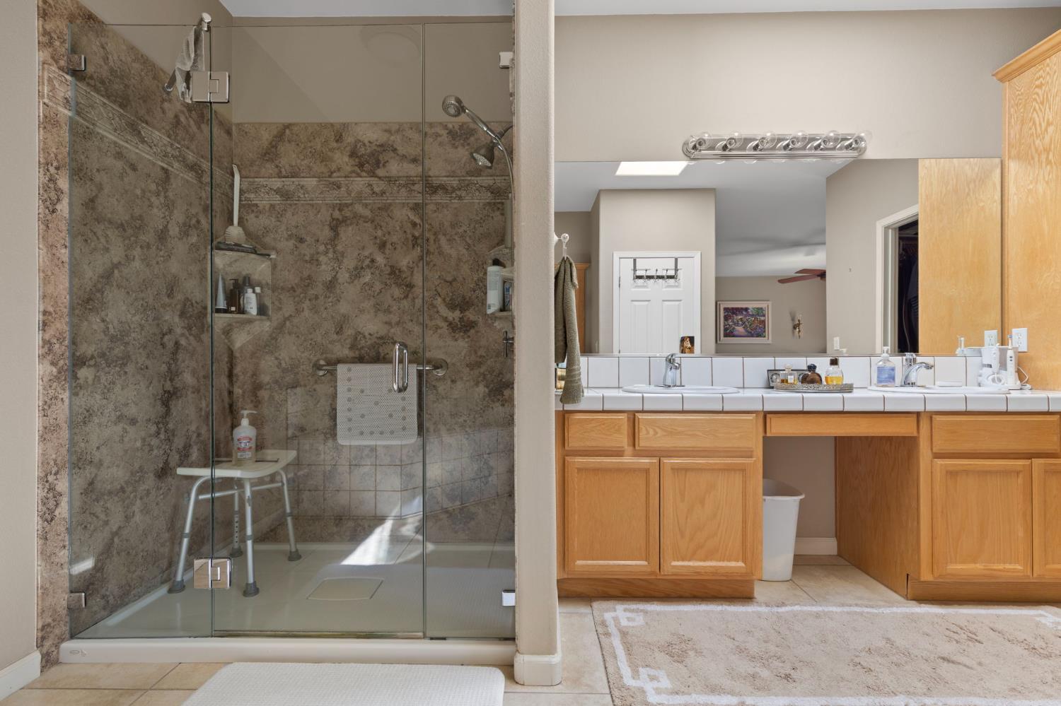 3235 Hagen Road Valley Springs, CA 95252 - Photo 24 of 40 a bathroom with a granite countertop sink mirror and shower
