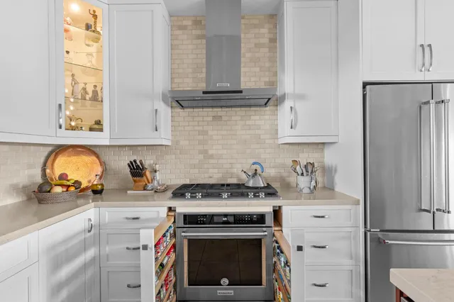 a kitchen with granite countertop a stove oven and white cabinets