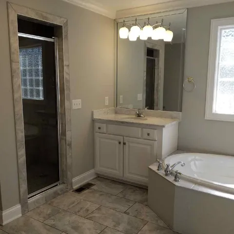a bathroom with a tub sink and mirror