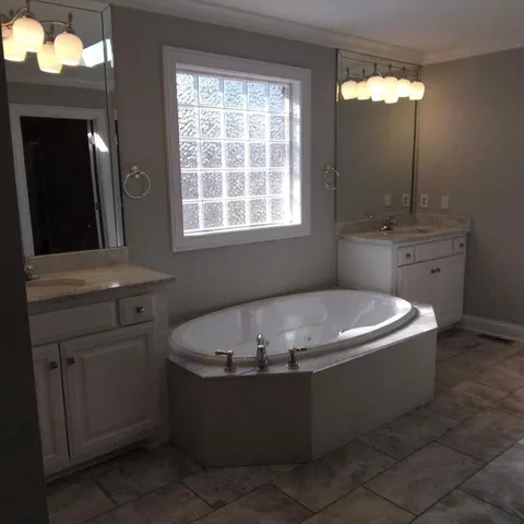 a bath tub sitting in a bathroom next to a window