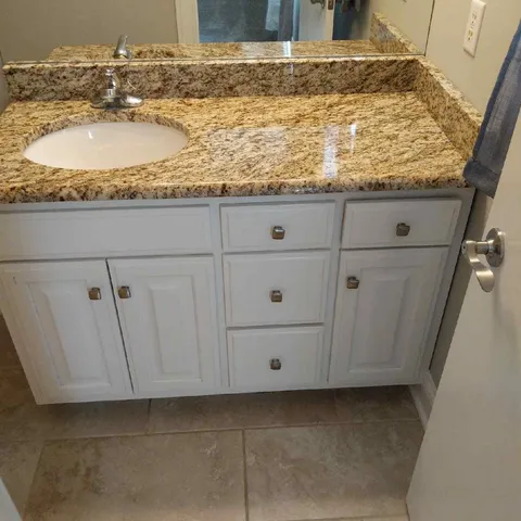 a bathroom with a granite countertop sink and vanity
