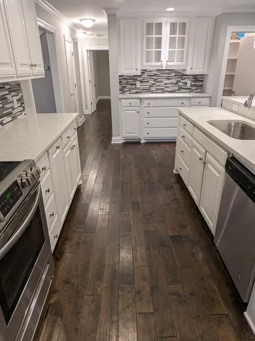 a kitchen with stainless steel appliances granite countertop a stove a sink and a refrigerator