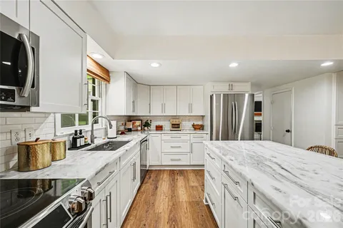a kitchen with a refrigerator a sink and wooden cabinets