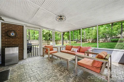 a view of a backyard with table and chairs and a barbeque