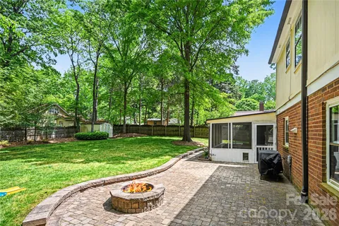 a view of a house with a big yard and large trees