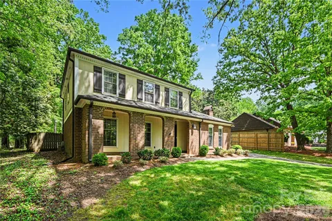 a front view of a house with yard and green space