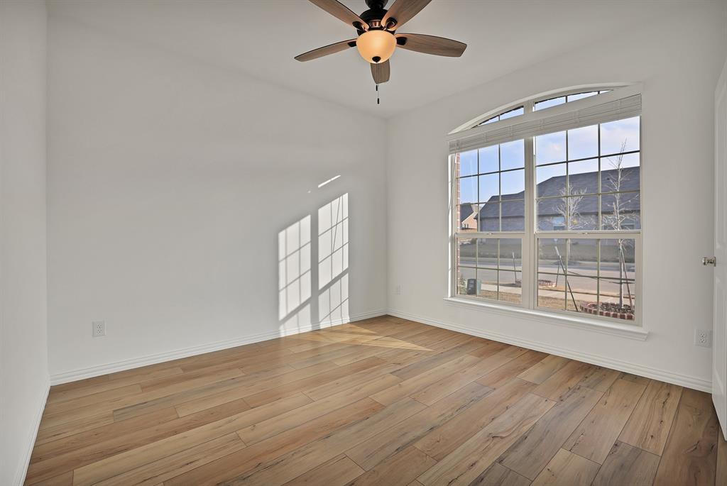 3204 Renaissance Drive Denton, TX 76207 - Photo 20 of 25 Bright room featuring wood-finish flooring, white walls, and a large arched window with horizontal blinds