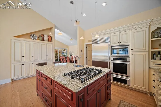 a kitchen with kitchen island a counter space a sink appliances and cabinets