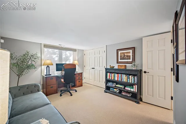 a view of a livingroom with workspace and a window