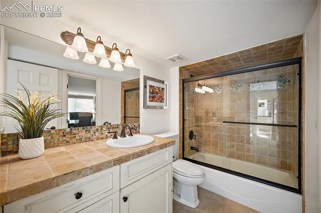 a bathroom with a sink a toilet and a large mirror