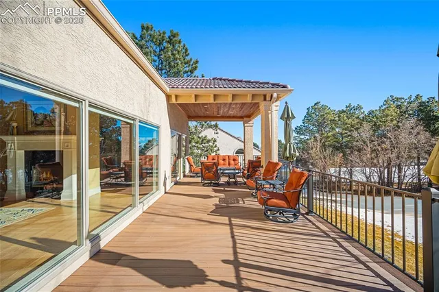 a view of a patio with table and chairs with wooden floor and fence
