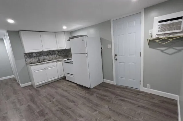a kitchen with a refrigerator and a stove top oven