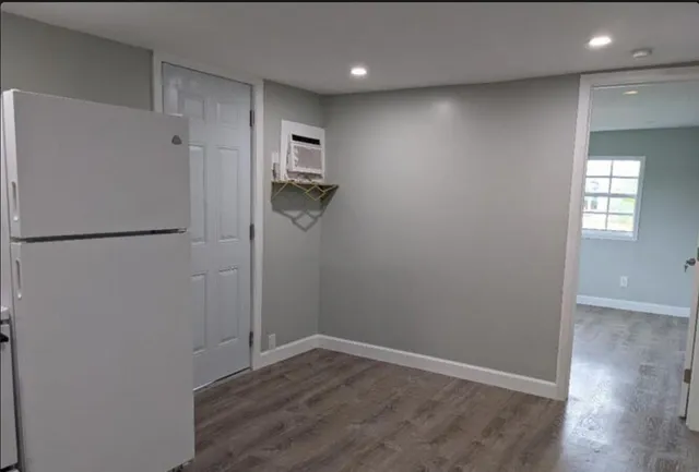 a view of empty room with wooden floor and window