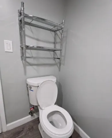 a white toilet sitting next to a shower