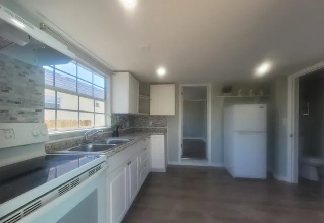 a kitchen with stainless steel appliances granite countertop a sink stove and refrigerator