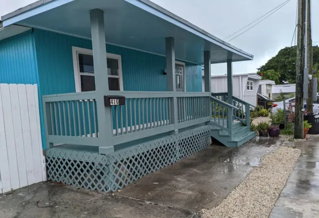 a view of a house with a small yard and wooden fence