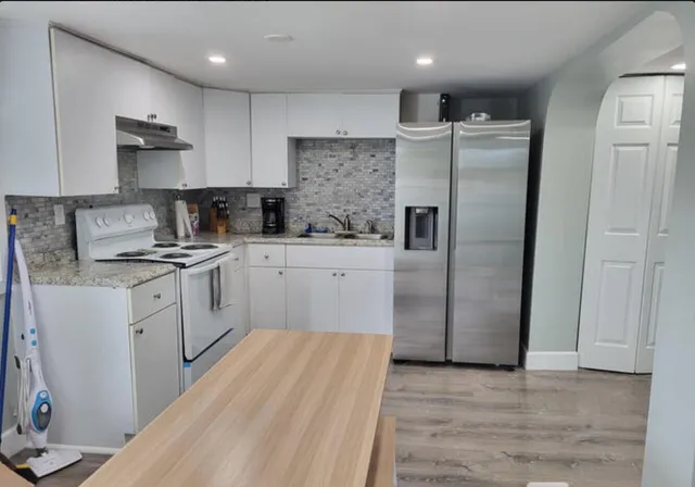 a kitchen with a refrigerator sink and cabinets