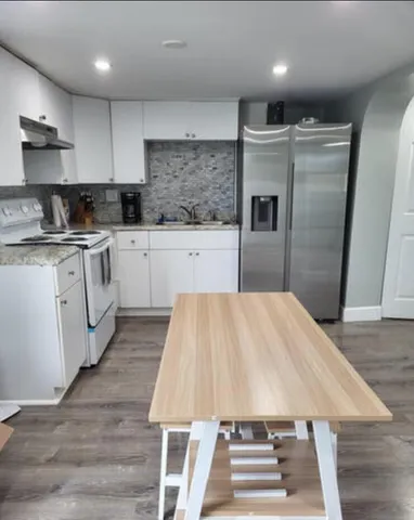 a kitchen with kitchen island a stove a sink and a refrigerator