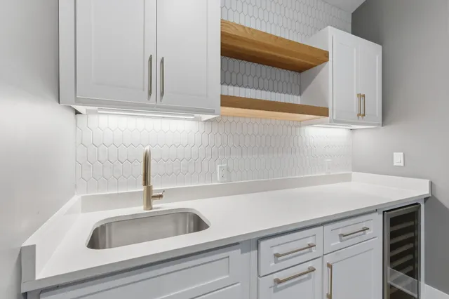 a kitchen with white cabinets and a sink