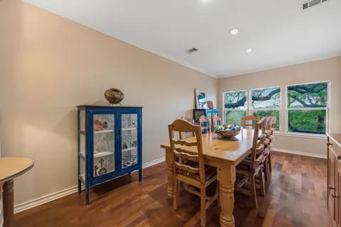 a view of a dining room and livingroom with furniture wooden floor a chandelier