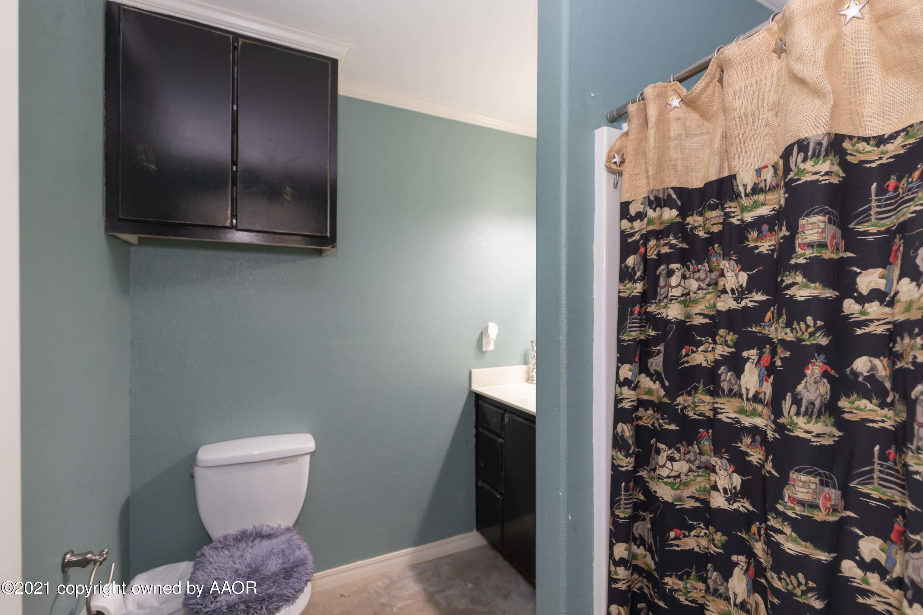 18400 Morning Star Road Bushland, TX 79124 - Photo 54 of 77 a bathroom with a toilet and a shower curtain