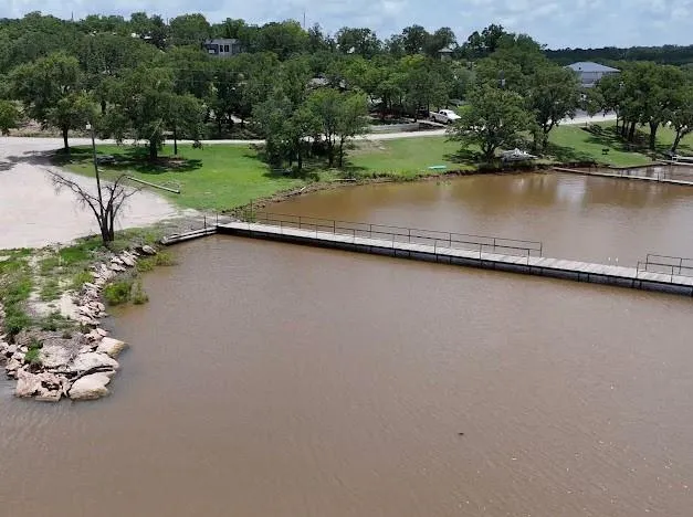 an aerial view of a house with a yard and lake view